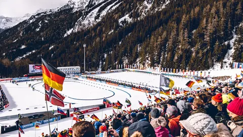 Biathlonstadion mit Strecke, Fahnen und Publikum